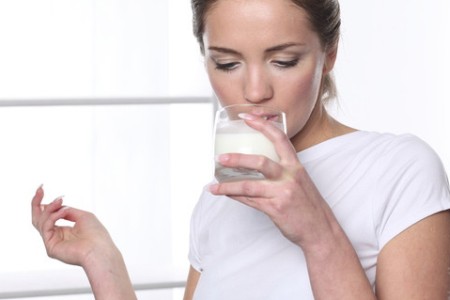 Женщина пьет молоко: кальций из натуральных продуктов или глюконта кальция