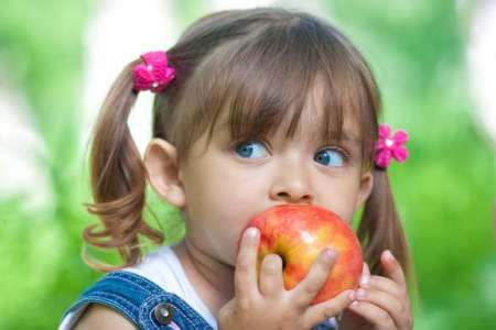 Девочка ест яблоко: что можно и нельзя при панкреатите у детей