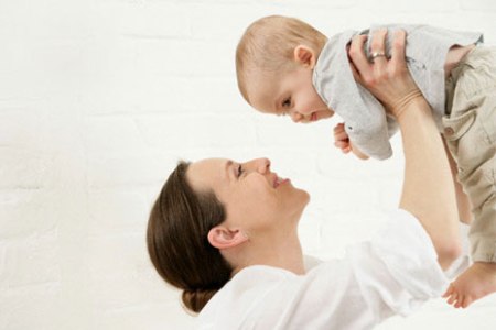 Женщина держит на руках ребенка: ограничение физических нагрузок - одно из последствий после кесарева сечения.