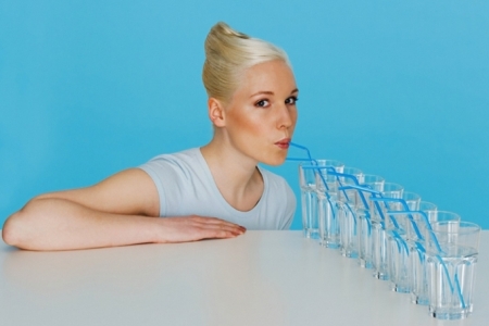 Женщина пьет воду: это помогает сбросить лишний вес при беременности 