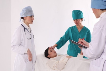 женщина на кушетке в больнице: за швом после кесарева сечения нужно внимательно следить, чтобы вовремя заметить возможные осложнения.