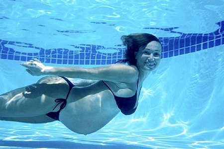 Беременная выполняет упражнения в бассейне