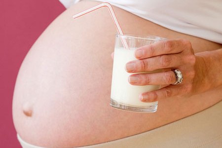 Беременная со стаканом молока: часто уреаплазму при беременности принимают за молочницу.