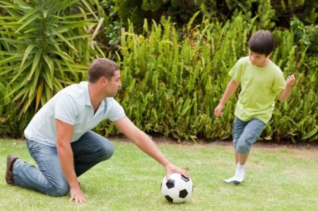 Отец играет с сыном с мячом
