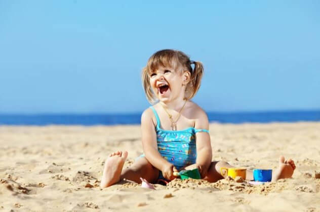 Девочка на пляже: кремы от солнца для детей