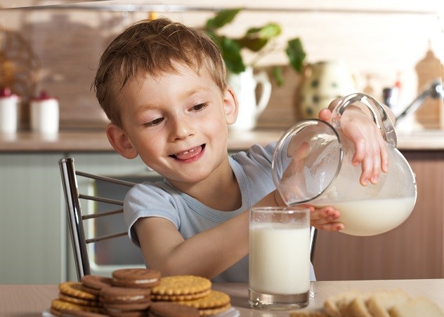 ребенок наливает молоко