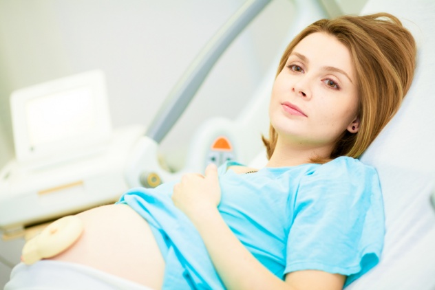 беременная лежит на кушетке в первом периоде родов