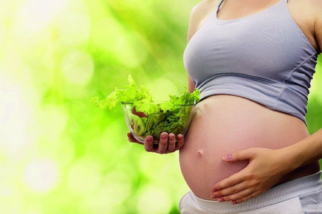 беременная держит миску с овощами