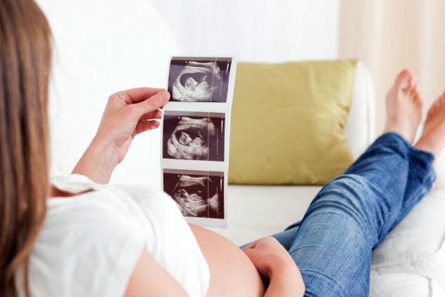 беременная смотрит на снимки УЗИ