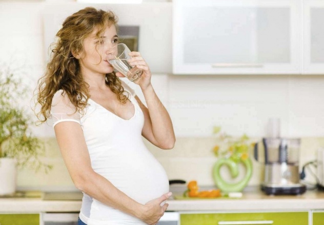 беременная пьет из стакана