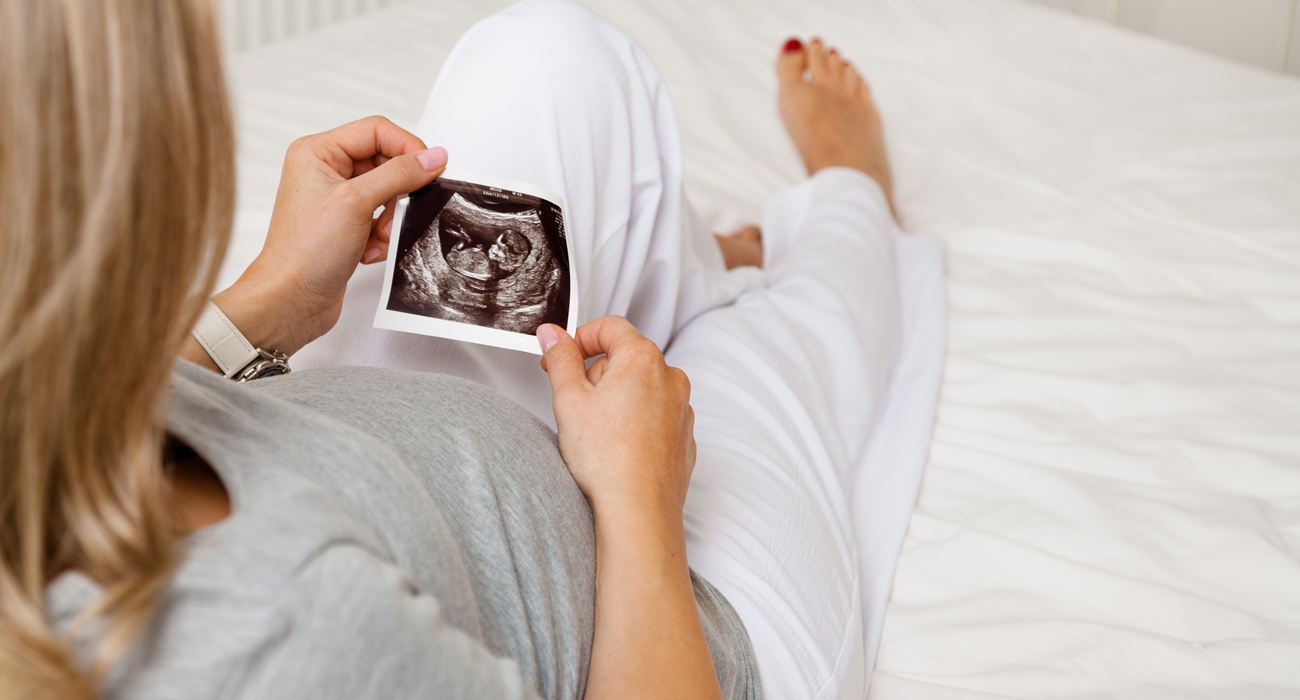 беременная смотрит на снимок УЗИ 