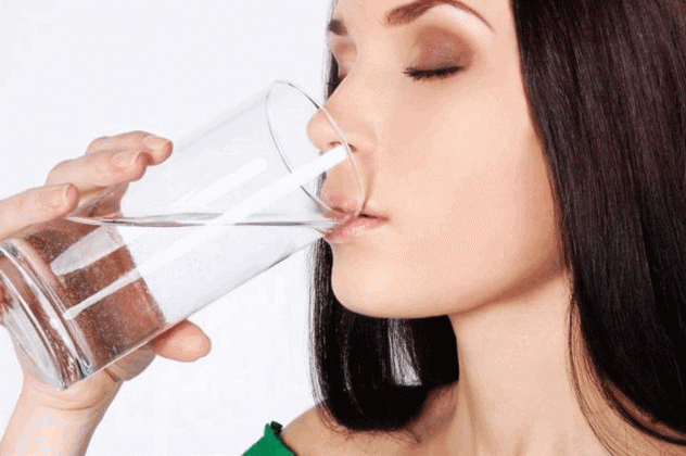 Женщина запивает таблетку водой