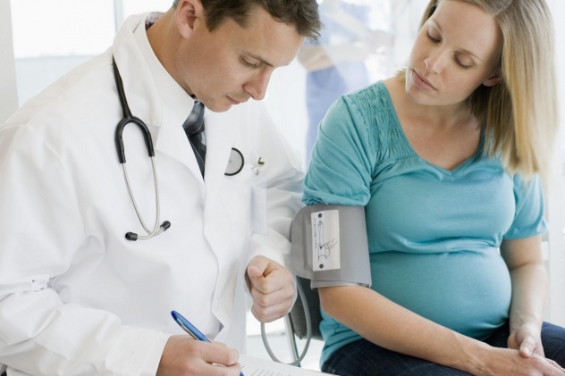 Доктор измеряет АД у беременной
