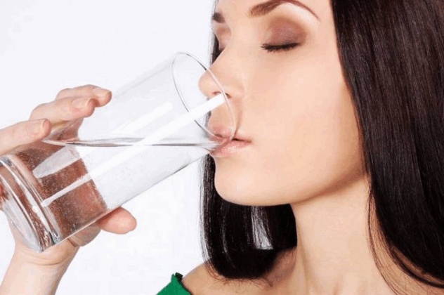 Женщина запивает Амоксициллин водой