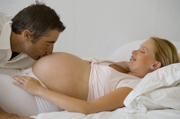 мужчина целует беременную жену