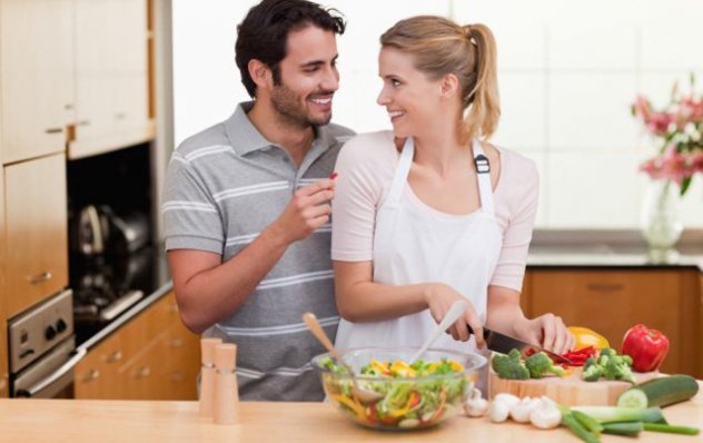 Молодая пара готовит салат