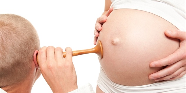 врач слушает как пульсирует живот при беременности